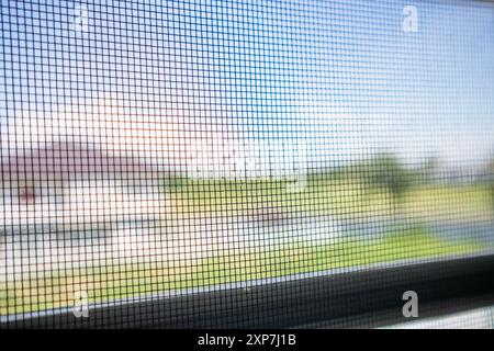 damaged mosquito net wire screen on house window protection against insect Stock Photo