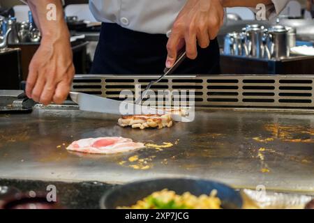 Japanese chef cooking meat in teppanyaki restaurant Stock Photo