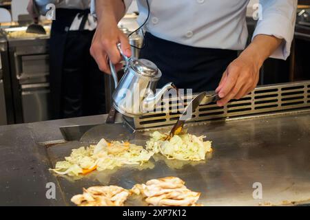 Japanese chef cooking meat and vegetable in teppanyaki restaurant Stock Photo