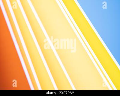 Energetic bands of sloped lines in orange, yellow, and blue Stock Photo