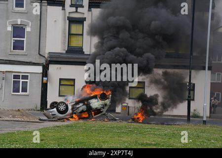 A car burns after being overturned during an anti-immigration protest in Middlesbrough. Picture date: Sunday August 4, 2024. Stock Photo