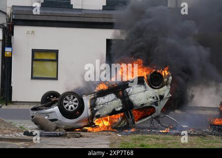 A car burns after being overturned during an anti-immigration protest in Middlesbrough. Picture date: Sunday August 4, 2024. Stock Photo