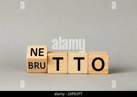 Netto and brutto. Net and gross symbol. Words on wooden blocks change net to gross. Financial concept, Beautiful gray background, copy space Stock Photo