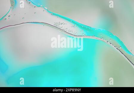 Abstract image featuring a flowing teal green liquid with suspended water droplets against a soft, white background. serene colors and fluid lines evo Stock Photo