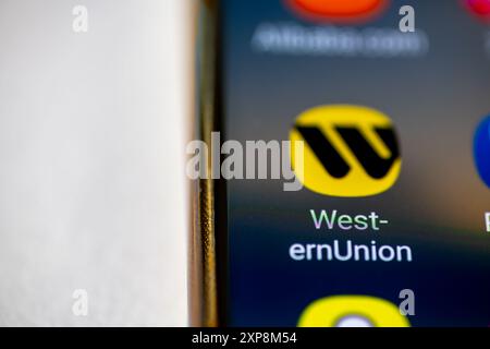 London. UK- 07.28.2024.The American financial services, money transfer app Western Union on the screen of a mobile phone isolated in white. Stock Photo