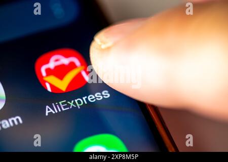 London. UK- 07.28.2024. The online retail service app AliExpress on the screen of an Android phone with a finger opening the application. Stock Photo