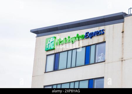 Rotherham, UK. 04 AUG, 2024. Persons housed in the hotel look out of the Windows towards the crowd  as hundreds of police and protestors clash outside a Holiday Inn Express on Manvers way, Rotherham. The right wing demonstrators, described by Sir Kier Starmer as 'thugs' set fire to property, smashed glass and fought with police for several hours. Multiple arrests and Injuries to rioters and police. Credit Milo Chandler/Alamy Live News Stock Photo