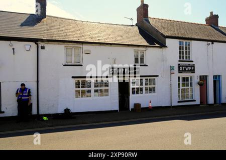 Security guard on duty outside filming location shop, Llantwit Major during filming of Death Valley BBC TV series. July 26th 2024. Summer Stock Photo