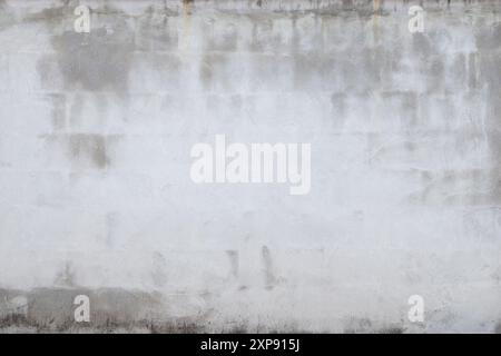 Front view of a weathered, aged and dirty plastered brick wall. Abstract high resolution full frame textured background, copy space. Stock Photo