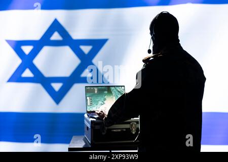 Israel Mossad agent working on laptop, analyzing aerial reconnaissance data to come up with warfare winning tactics. Intelligence corps agent controlling drones attacking strategic targets Stock Photo