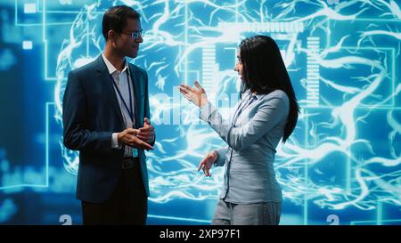 Computer scientists use AI neural networks modeled after human brain to solve complex problems. Startup employees using artificial intelligence to look at data and complete tasks, camera A Stock Photo