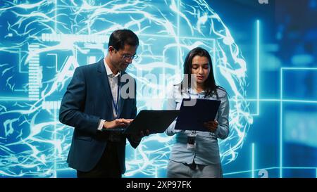AI researcher and coworker working with artificial intelligence neural networks. Computer scientists collaborating on developing AI system in high tech workspace, camera A Stock Photo