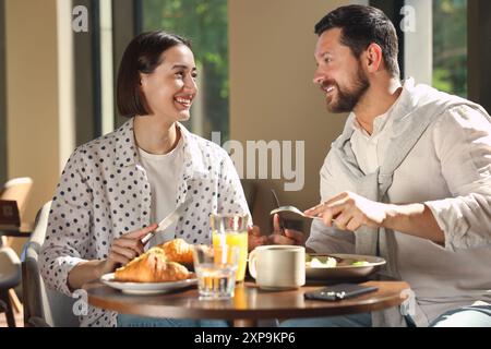 Happy couple having tasty breakfast in cafe Stock Photo