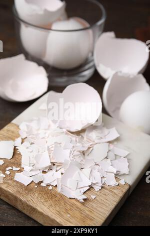 Pieces of broken eggshells on wooden table, closeup Stock Photo