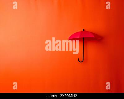 Top view red umbrella on a orange background with copy and text space. Stock Photo