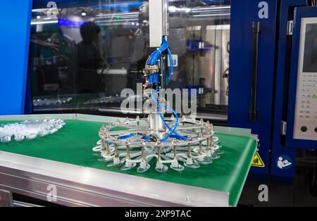 Close-up of plastic spoon production on plastic injection molding press machine Stock Photo