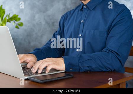 Happy man in office, typing on laptop and planning online research for creative project at professional digital agency. Internet, website and networki Stock Photo