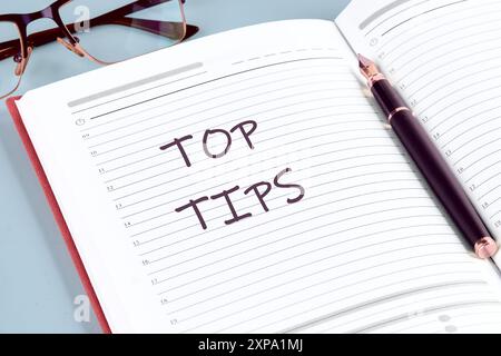 Top tips. Inscription TOP TIPS word in the notebook of a businessman, manager Stock Photo
