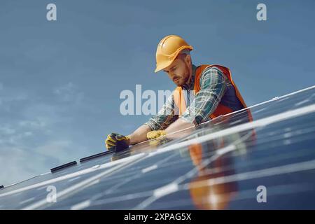 Installing solar panels on house roof. Men technicians carrying photovoltaic solar module on roof of house, system green house eco industry Stock Photo