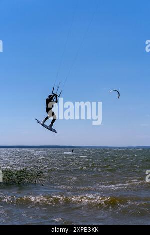 Man do tricks with his board practicising kitesurf jump in the air ...