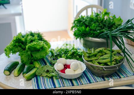table with various greens and fried eggs. Preparations for canning. High quality photo Stock Photo