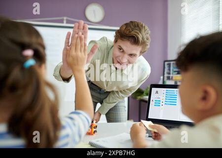 School Teacher Interacting with Students in Classroom Stock Photo