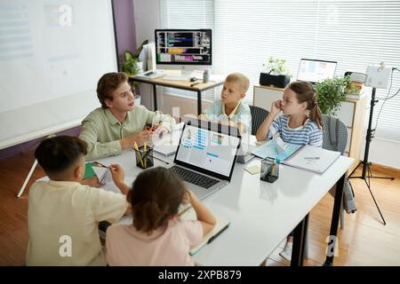 Teaching Group of Children in Modern Classroom Setting Stock Photo