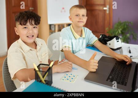 Smiling Boys Working Together on Digital Project Stock Photo