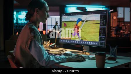 Portrait of Female Video Game Designer Working on a New 3D Level on Her Desktop Computer. Focused Woman Creating Metaverse and Design Video Game Character in Creative Office at Night Stock Photo