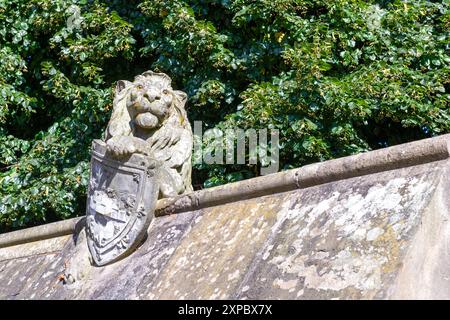 Stone lion with heraldic shield on Animal Walk, Bute Park, Cardiff UK. Sculpture in 1880s by William Frame to the designs drawn by William Burges. Stock Photo