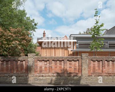 View from street with perimeter wall and extension facade. Rambert School of Ballet, London, United Kingdom. Architect: MICA, 2023. Stock Photo