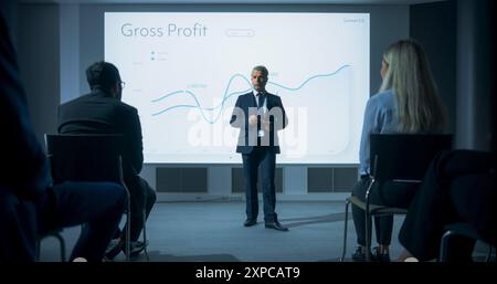 Corporate Event: Caucasian Male Tech CEO Giving Presentation To Colleagues or Investors In Conference Room Of Innovative Startup Office. Man Talking About Business Objectives and Profit Margins. Stock Photo