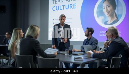 Corporate Event: Caucasian Male Tech CEO Hosting Team Building Workshop With Diverse Employees In Conference Room Of Innovative Startup Company Office. Successful People Discussing Business. Stock Photo
