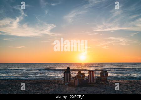 А family is watching sunset on a beach in Venice, Florida Stock Photo