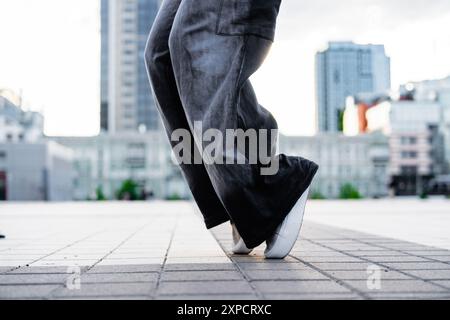 Person Practicing Dance Moves on Urban Pavement During Daytime in Modern City Environment Stock Photo