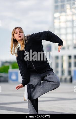 Young Dancer Performing Dynamic Moves in Urban Space During Late Afternoon Stock Photo