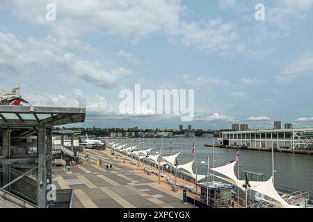 New York, NY, USA - August 3, 2023: View over Pier 86 onto New jersy shore. Part of Intreprid aircraft carrier museum visible with airplane Stock Photo