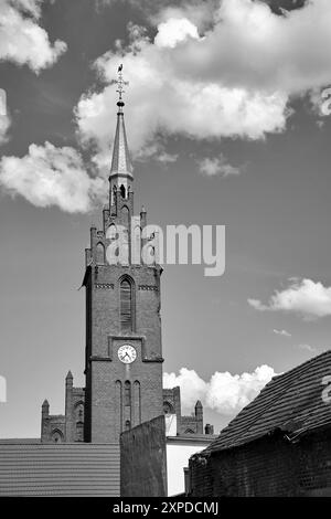 the bell tower of the historic gothic church  and roofs made of red tiles in the village of Bledzew, Poland,  monochrome Stock Photo