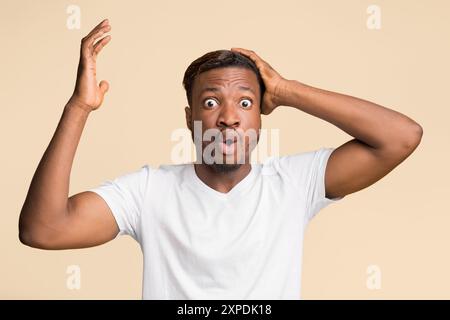 African American Man Clutching His Head And Gesturing In Studio Stock Photo