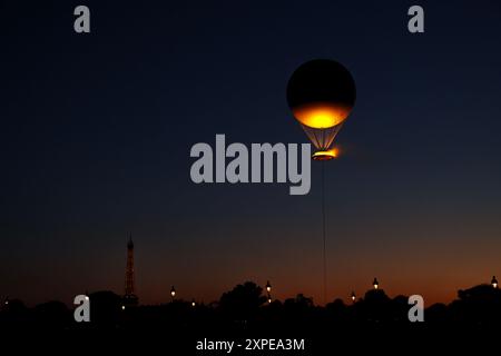 Paris, France. 05th Aug, 2024. Paris Olympics: Tuileries Gardens - The Olympic flame floats above the Tuileries Gardens in Paris as thousands of people watch each night. The Eiffel tower is also visible Credit: Adam Stoltman/Alamy Live News Stock Photo