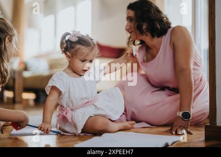 Loving mother spending quality time with her daughters at home Stock Photo