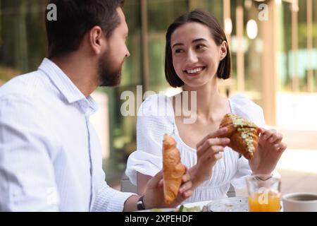 Happy couple having breakfast in outdoor cafe Stock Photo