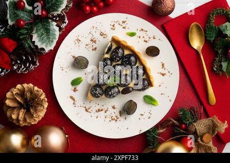 Delicious black grape cake with pastry cream on a table with Christmas decorations. Stock Photo