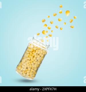 Jar with corns in air on light blue background Stock Photo