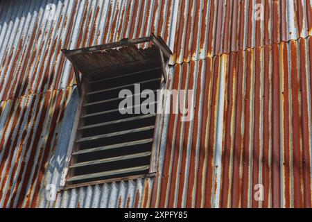 Metal sheet house with windows rusted and damaged. Exterior of a ...