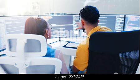 Back, team and computer screen in office for code, web development and software programming. Man, woman and developers in talk for cybersecurity Stock Photo