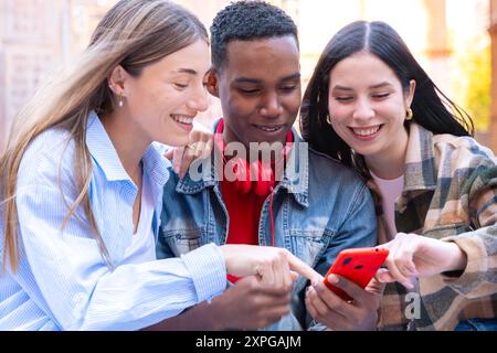 Three students having fun with mobile phones creating content on social media. Stock Photo