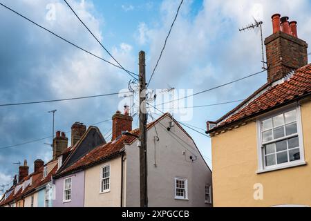 Telephone wires running to cottage roofs in Southwold, Suffolk, UK. Old technology. Telephone post. Old cottages. England. 2024 Stock Photo