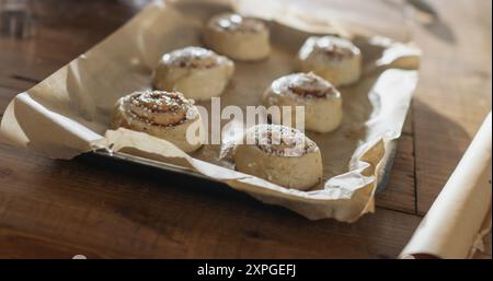 Close Up Making Of Cinnamon Buns to Share with Family and Friends for Christmas. Delicious Buns Being Buttered to be Cooked for Holiday Evening Guests Stock Photo