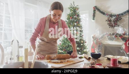 Young Woman Preparing the Dough to Make Gingerbread on Christmas. Loving Mother Preparing Pastries for her Family on For the Holiday Season Stock Photo